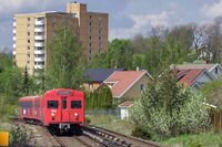 Et tog mellom Hellerud og Godlia med blokkbebyggelse på Tveita i bakgrunnen. Foto: Leif-Harald Ruud (2005).