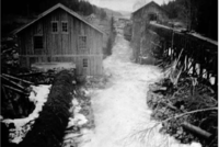 Her har fotografen med ryggen mot Mønevann fanget Østmarksaga med den svære vassrenna på høyre side av Losbyelva. Foto Lørenskog Bygdemuseum.