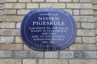 Blå plakett på skolens tredje bygning, Øvre Vollgate 15. Foto: Chris Nyborg (2013).