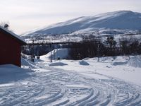 Lønsdal stasjon i forgrunnen, Gæbdnevárrdo/Kjemåfjellet attom. Foto: Olve Utne (mars 2010).