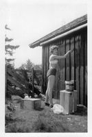 1960. Reidunn ved do-døra. Takrenne av en trestokk.