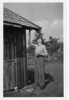 1960. Far Kjell maler uthuset, her ved vedskålen.