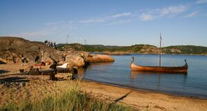 Strand, scene og vikingskip.