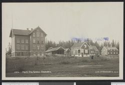Grav skole med omkringliggende bebyggelse. Foto: Nasjonalbiblioteket