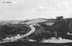 Skjettenveien krysser Sagelva. Ryendammen og Nedre Ryen gård til høyre, Søndre Skjetten gård til venstre (1917).