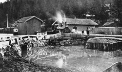 Bryn stasjon med Loelva - nå Alnaelva - i forgrunnen. Foto: Origo - Norske jernbanestasjoner (1858).