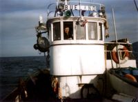 «Bueland» på veg til hamn. I rorhuset eigaren Olai Hillarsøy.