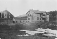 Skolebygningen med elever på balkongen.