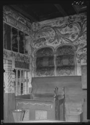 Døypefonten frå kring 1600 og rosemåla veggar. Foto: Ukjend / Nasjonalbiblioteket