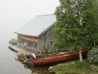 En femundbåt dratt opp ved et båthus (naust) i Elgå. Foto: Olve Utne (2015).