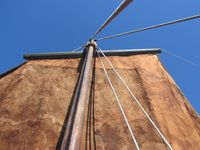 Vi ser opp mot mastertoppen. To vant står i lo (øvst); eitt står i le, og attom dét er fallet. Seglet er eit lårsegl. Foto: Olve Utne (2017).