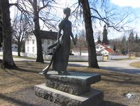 Statue av den unge Camilla Collett ved Eidsvoll kirke, utført av Ada Madsen (1977). Foto: Stig Rune Pedersen