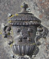 Detalj fra liggende gravminne ved Eidsvoll kirkegård. Motiv: urne med dødningskalle. Foto: Stig Rune Pedersen