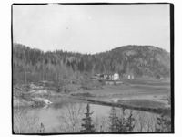 En gård ved et vann. Men hvor? Foto: Marthinius Skøien (omkr. 1880-1910).