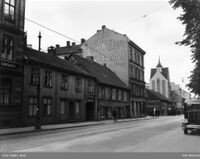 Grønlandsleiret 57 (trebygningen til venstre) i Oslo, ble på begynnelsen av 1900-tallet benyttet som et privat pleiehjem, betalt av fattigvesenet, for opptil 20 hjemløse menn som hadde tuberkulose. Mennene skulle kunne klare seg selv. Ole Evensen hadde opphold her da han døde i 1907, av tuberkulose. Bildet er fra 1935 Foto: Oslo Museum