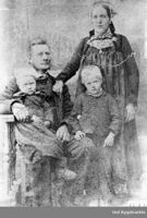 Bilete 2: Foreldra til Anne, Mari og Tolleiv, båe helgekledd, med to av ungane. Ukjent fotograf, Hol bygdearkiv, ca. 1880.