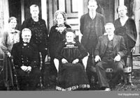 Bilete 4: Mari omkransa av sju av borna i Søre Juvsjordet. Som mora har Anne (øvst i midten) konehette, så biletet må tidlegast vera frå 1911, då ho gifte seg. To av brørne har også hallingklede. Ukjent fotograf, Hol bygdearkiv.