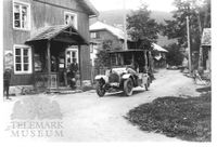 Folkestadbyen, hovudgata. Frå v. forretning, delvis skjult ein forretning og så hotell bak bilen, ein La Buire.