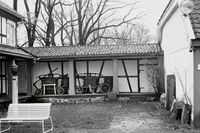 Gamle brannsprøyter fra museets samling i svalen mellom hovedbygning og østfløy. Foto: Halvor Vreim (1958).