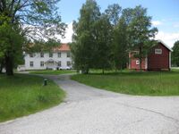 Prestegarden med innkøyringa og tunet. Uthuset er til venstre. Foto: Olav Momrak-Haugan 2017