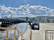 Den gamle bybrua til venstre under riving og med en midlertidig gangbru. Foto: Egil Øygard (mai 2022).