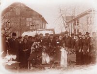 Dette syner gravferda til Anne Gunnarsdatter i 1911 på Øystad. Bordet er duka med velferdsdram. Bak til venstre er Handelslaget, til høgre Breifonn og det vesle huset med pipe er vaskehuset til Ingebjørg. Foto: Olav S. Nylid 1911.