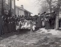Gravferd i Folkestadbyen. Til venstre er Bygdheim og lengre bak er Lauvstad øvre. Årstal er ukjent, men fotograf er Olav S. Nylid