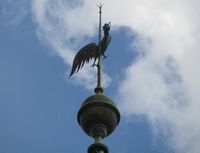 Nærbilde av spiret i toppen av tårnet på Grorud kirke, med dekorativ hane. Foto: Stig Rune Pedersen