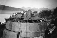 Harald Sverre Olsen og Halvar Nergaard har røykepause på toppen av oljetanken til Kvedfjord sildoljefabrik. Foto: Ukjent. Utlånt av Anny Sørensen.