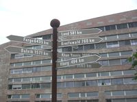 Skilt foran rådhuset i Hamar med avstand til Hamars vennskapsbyer.