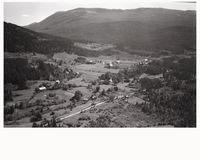 Bygningen oppe til venstre er Bergland og garden i venstre del av biletet er Øvre Haugane. "Sykkelhuset" er i bakken rett opp frå fylkesvegen, venstre del. Foto frå NV: Widerøe 1949