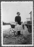 Helmine Paulsberg med Sverre i barnevogn ved trappa på nordsiden av huset i Paulsberg på vinteren/våren 1937. Fotografert mot øst. Foto: Ukjent, 1937