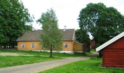 Huseby gård 2012. Hovedbygningen med smia i forgrunnen. Foto Steinar Bunæs.