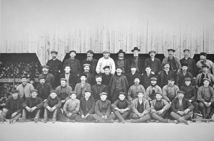 ARBEIDERE PÅ NÆRSNES CA 1900-1910. Sesongarbeid på Teglverket, i skogen eller med is. Bildet er tatt foran en av teglverksbygningene. Rekke 1 (nederste) fra v: Johan Fjeldheim, Martin Løkkeberget, Martin Sand, Oskar Arnold Gjertsen, Oskar Kjærnes, Endre Endresen, nn, Hagbart Vilhelm Hansen Høyum, Alexander Jacobsen, Botolfsen. Rekke 2 fra v: Johan Brevik, Johan Fridtjof Kjærnes, Oscar Tangen, Hjalmar Larsen, nn, nn, nn, nn, nn, nn, nn. Rekke 3 fra v: kjøpmann Isachsen, Lars Kirkerud, Hans Reinertsen, Aksel Grundvig, Jacob Kjærnes, Kristian Bjerknes, Hans Hagan, Gustav Nilsen, Karl Oscar Tangen, Fritjof Selvik. Rekke 4 fra v: Johan Svendsen, Karl Høvik, Caspersen, Bernt Vadfisker, Per Grundvig, Reinertsen, Johan Høybråten, Carl Heym, Tor Reinertsen, Edvard Vestby (Foto fra Nærsnesalbumet, fotograf ukjent)