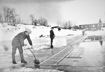 ISSKJÆRERE PÅ SCHWARTZEDAMMEN 1912-1920. Søndre Nærsnes gård i bakgrunnen. Dette bildet av Oscar Ellefsen er modell for isskjærerfiguren som Ole Sønju laget, og som pryder veggen på Nærsnes Grendehus.(Foto fra Nærsnesalbumet, fotograf ukjent)
