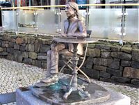 Nina Nesjes bronsestatue av en sittende Jahn Teigen, ved Jahn Teigens plass ved brygga i Tønsberg. Foto: Stig Rune Pedersen