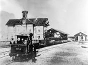 Damplokomotiv type I nr. 2 med Hamars stasjonsbygning, toghallen og lokomotivstallen i bakgrunnen 1862.