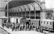 Stasjonspersonalet utenfor Østbanehallen; kareter og godsvogner i og utenfor hallen 1898. Kilde: Jernbanemuseet