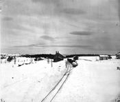 Heimdal stasjon med høye brøytekanter og godsvogner i spor 2.