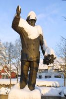 Kong Olav-monumentet i Asker er en en 2,5 m høy bronsestatue som står på terrassen ved Vektergården i Asker sentrum, viser kong Olav i admiralsuniform idet han vinker til folket. Foto: Svend Aage Madsen (2002).