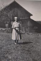 Helga Kalrustad foran låven. Hun og svigerinna Ranveig bodde i hovedbygningen da garden ble leid bort.