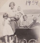 Johanne Kjølaas med Aud på armen og Bjørg og Leif ved vognen. På promenaden i Kirkenes. Foto: Gustav Kjølaas, 1934.