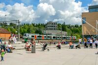 Folkeliv på Kolbotn torg. Et tog i retning Oslo ankommer Kolbotn stasjon. Foto: Leif-Harald Ruud (2009)
