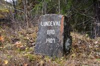Steinen låg mange år i elva, men vart tatt opp og sett ved sida av den nye Lundevall bru i Dampedalen. Foto: Roy Olsen (2021).