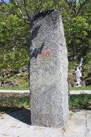 Minnestein ved Verma stasjon med monogrammet til Haakon 7. frå opninga av banen, hoggen av Einbu