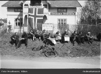 Moelv 8. mai 1945. Folk leser Oslo-avisene. Foto: Håkon Prestkværn