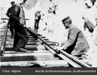 Sammenskjøting av skinnegangen fra nord og sør i Nystubekk skjæring mellom Kongsvoll og Drivstua; banemester Sørum måler kappet. Kilde: Jernbanemuseet