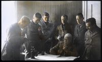 NPRA196. Planlegging av ekspedisjonen. Roald Amundsen (sittende), Leif Dietrichson, Lincoln Ellsworth, Emil Andreas Horgen, Karl Feuch, Hjalmar Riiser-Larsen og Oskar Omdal. Foto: Nasjonalbiblioteket