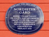 Blå plakett på våningshuset. Foto: Stig Rune Pedersen (2013).