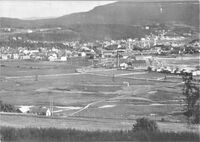 Nordsileira sett fra Egge gård ca. 1910. Vi ser taugbanebukkene fra Helge-Rein-By bruk, jernbanens sidespor fra Hell-Sunnan-banen ut mot Bogakaia i Eggebogen, Dampsaga og jernbanebrua over Steinkjerelva. Foto: Egge Historielag